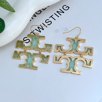 Acrylic logo drop earrings with gold-tone hooks and teal/green cutout letters