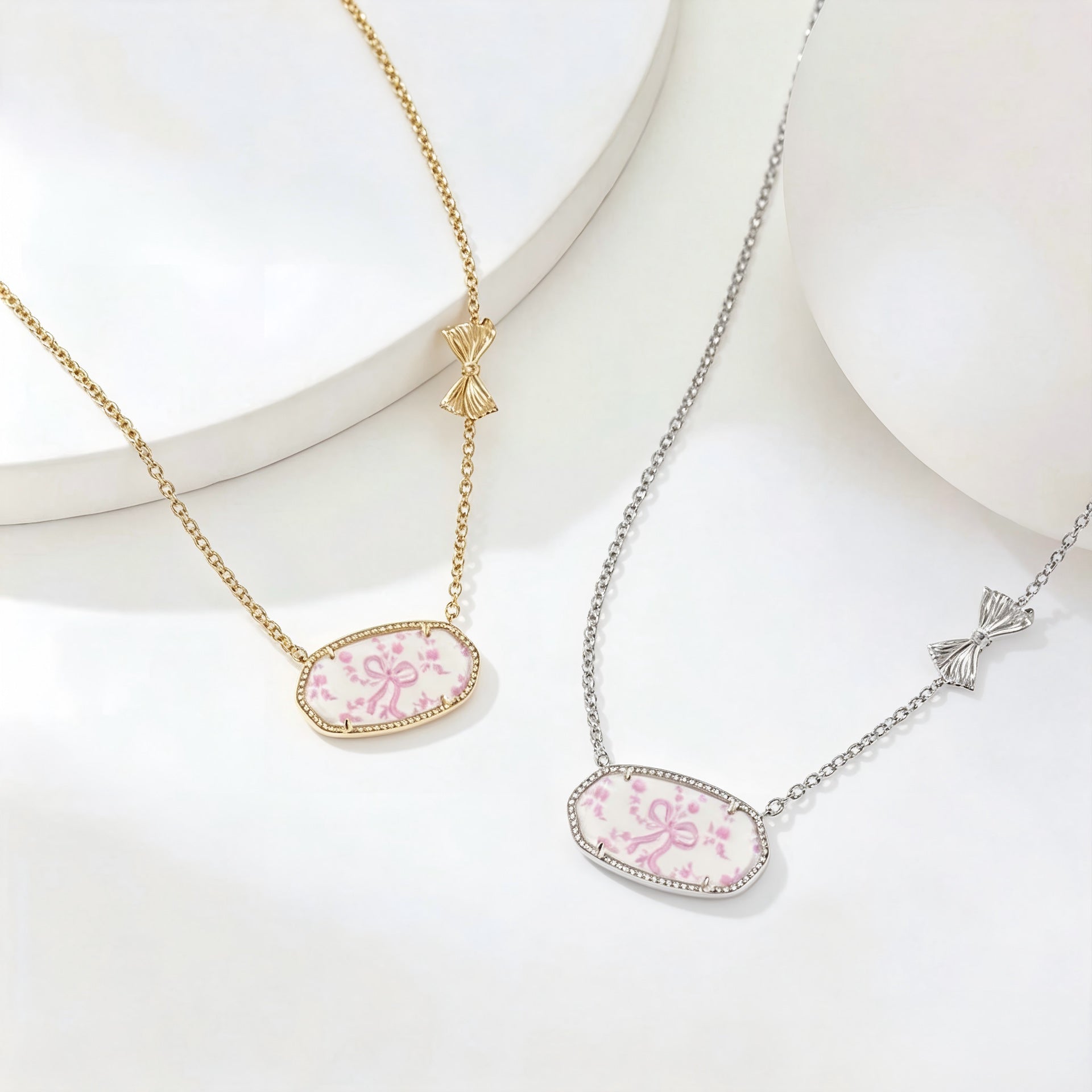 Gold- and silver-tone oval pendant bow necklaces with pink floral enamel