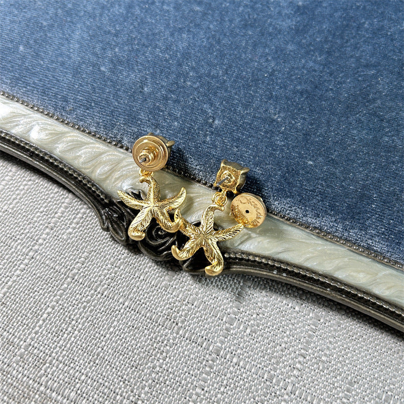 Gold starfish stud earrings with star-shaped drops and posts