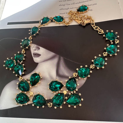 Gold-tone crystal necklace with teal/emerald oval stones and linked chain