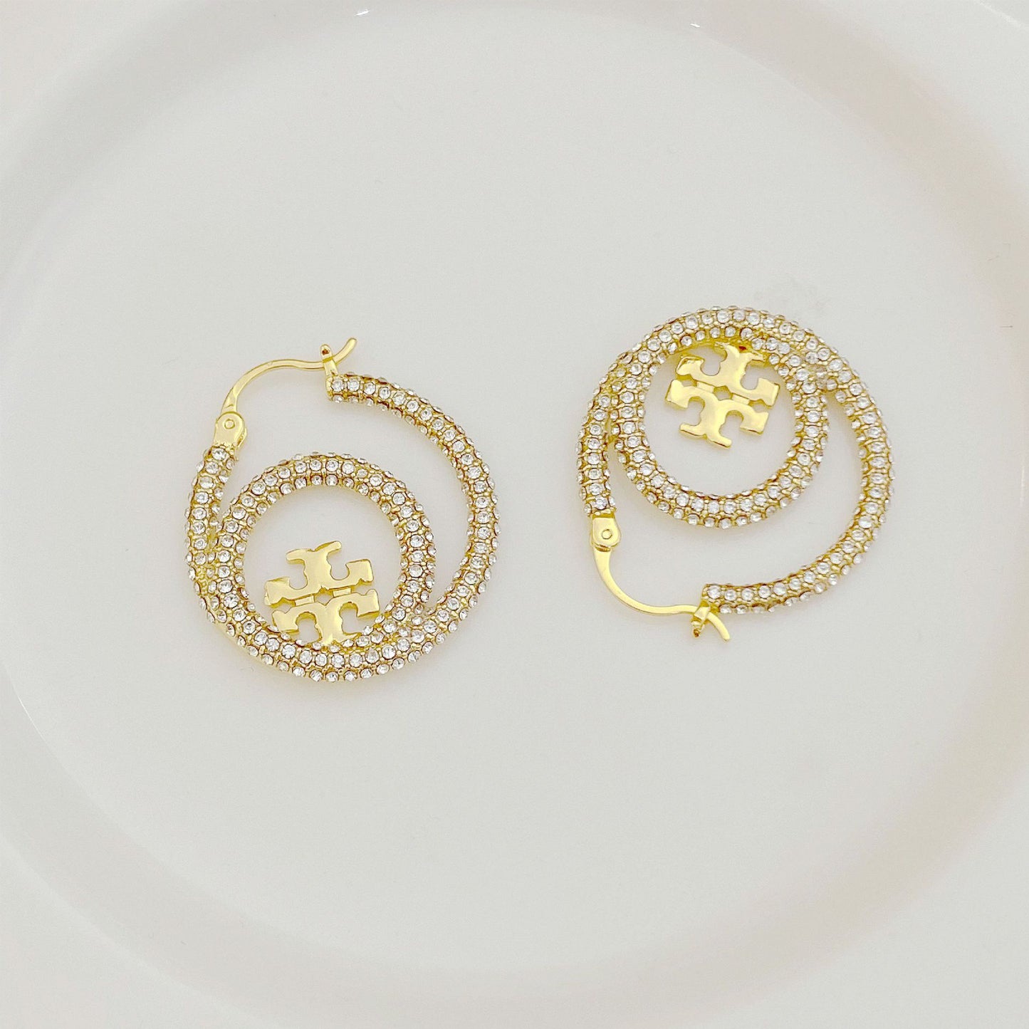 Gold hoop earrings with full diamond pavé and centered Tory Burch logo disk