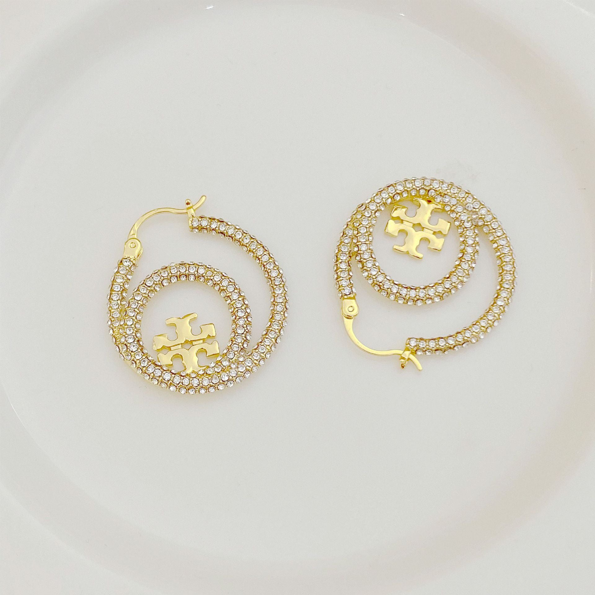 Gold hoop earrings with full diamond pavé and centered Tory Burch logo disk