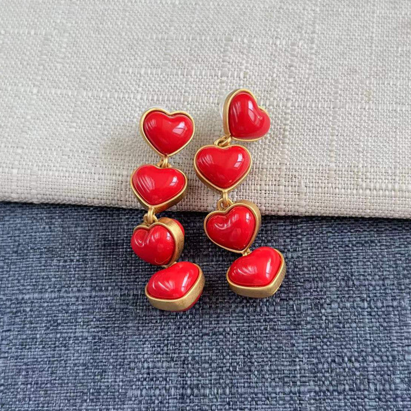 Heart-shaped long drop earrings with glossy red heart charms and gold-tone links