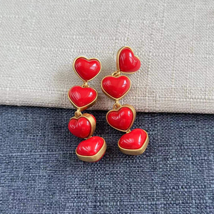 Heart-shaped long drop earrings with glossy red heart charms and gold-tone links