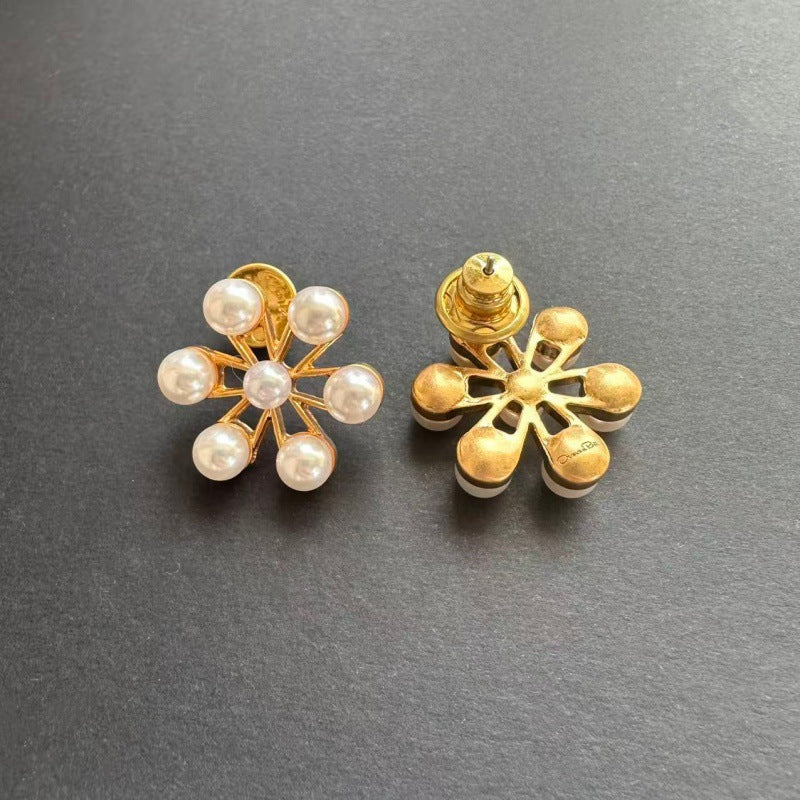 Gold-tone pearl flower earrings shown from the side with stud posts