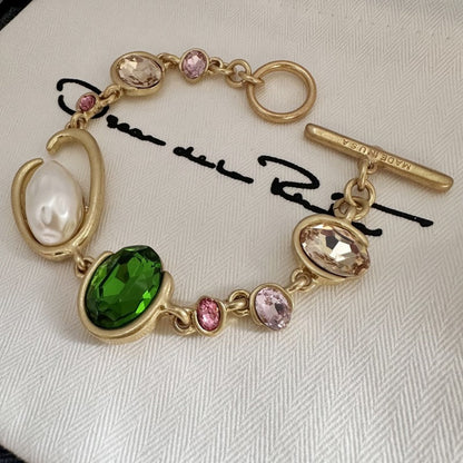 Gold-tone crystal and pearl O-ring bracelet with green oval and pink crystal drops