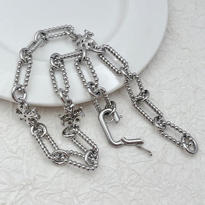 Silver square chunky chain logo bracelet with clover-like emblem charm links and toggle