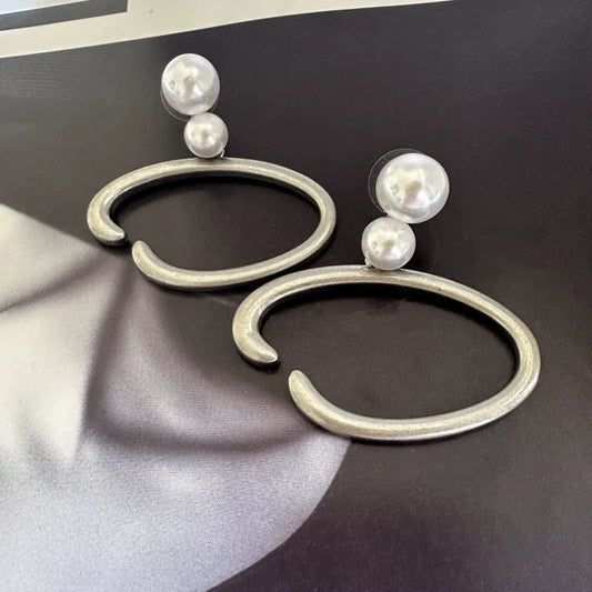 Silver-tone O-ring hoop earrings with two white pearls on each earring