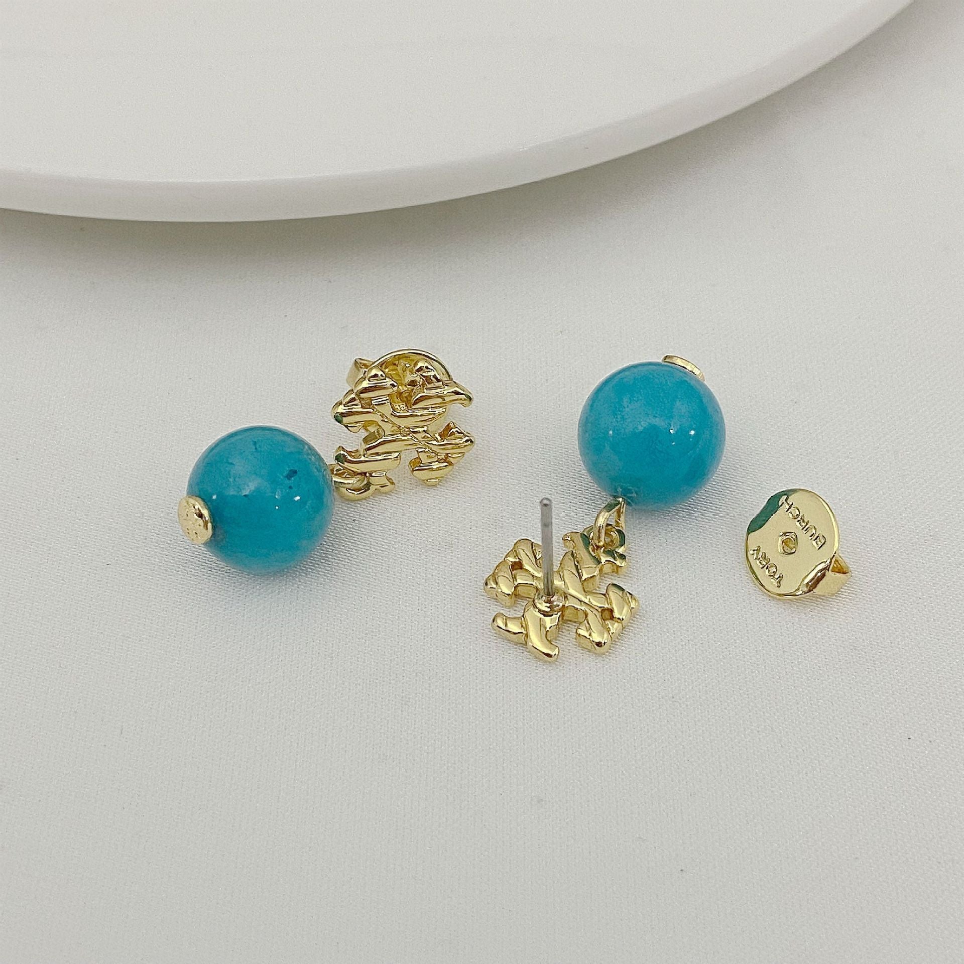 Agate pendant earrings with round blue beads and gold-toned textured lion-head details