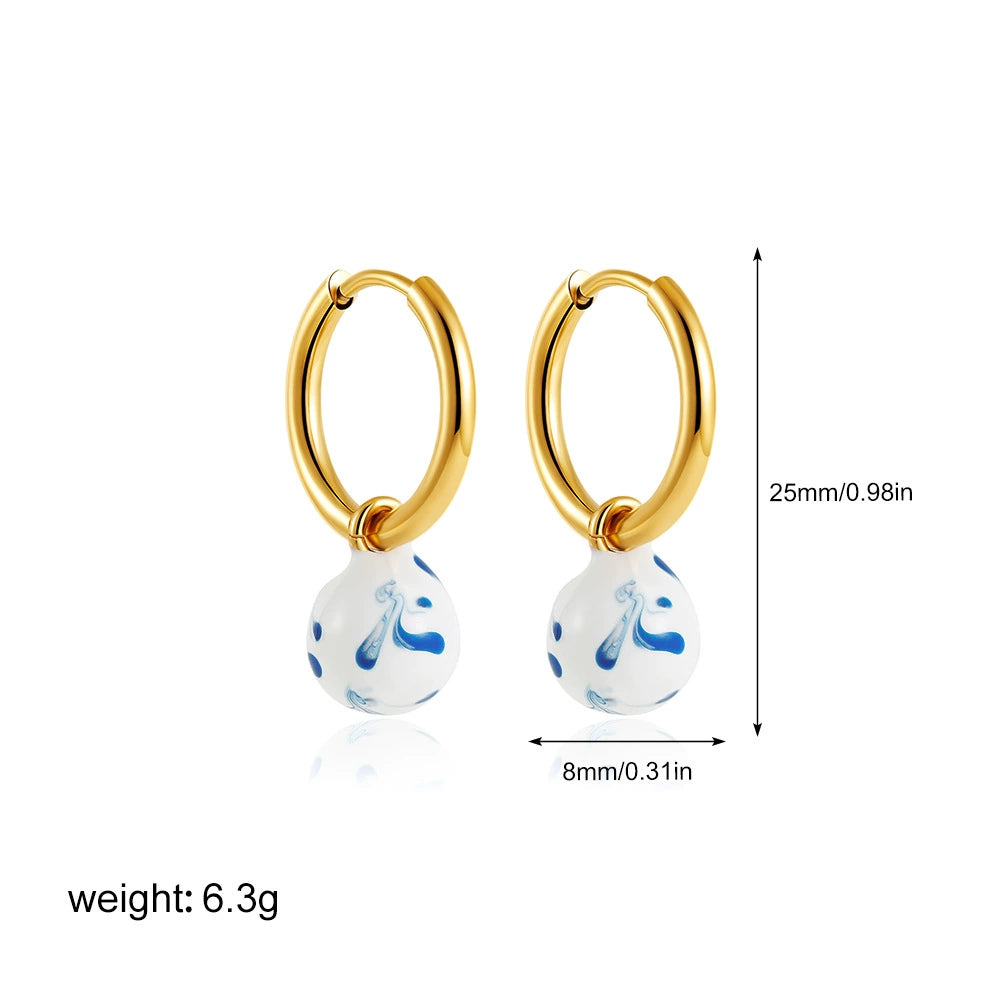 Gold-tone hoop earrings with small blue marble teardrop charm, 25mm