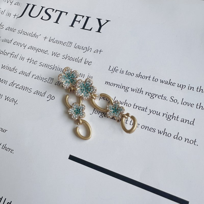 Floral dangle hoop earrings in gold tone with teal and clear crystal flower clusters