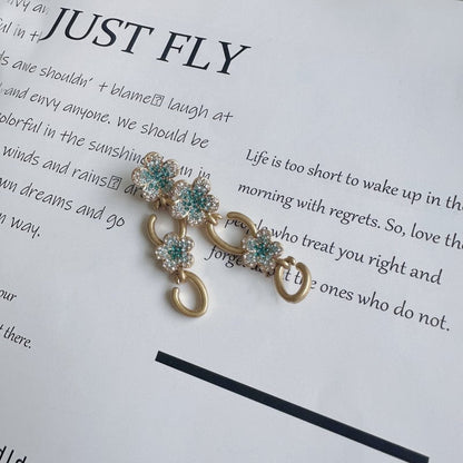 Floral dangle hoop earrings in gold tone with teal and clear crystal flower clusters