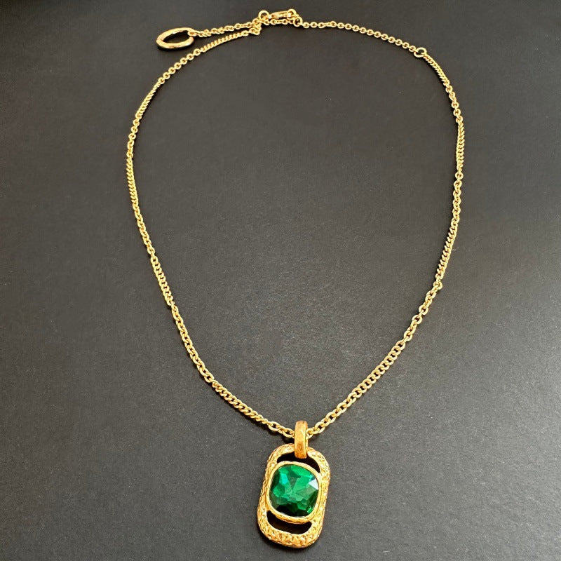 Gold chain square pendant necklace with hammered texture and green faceted gem