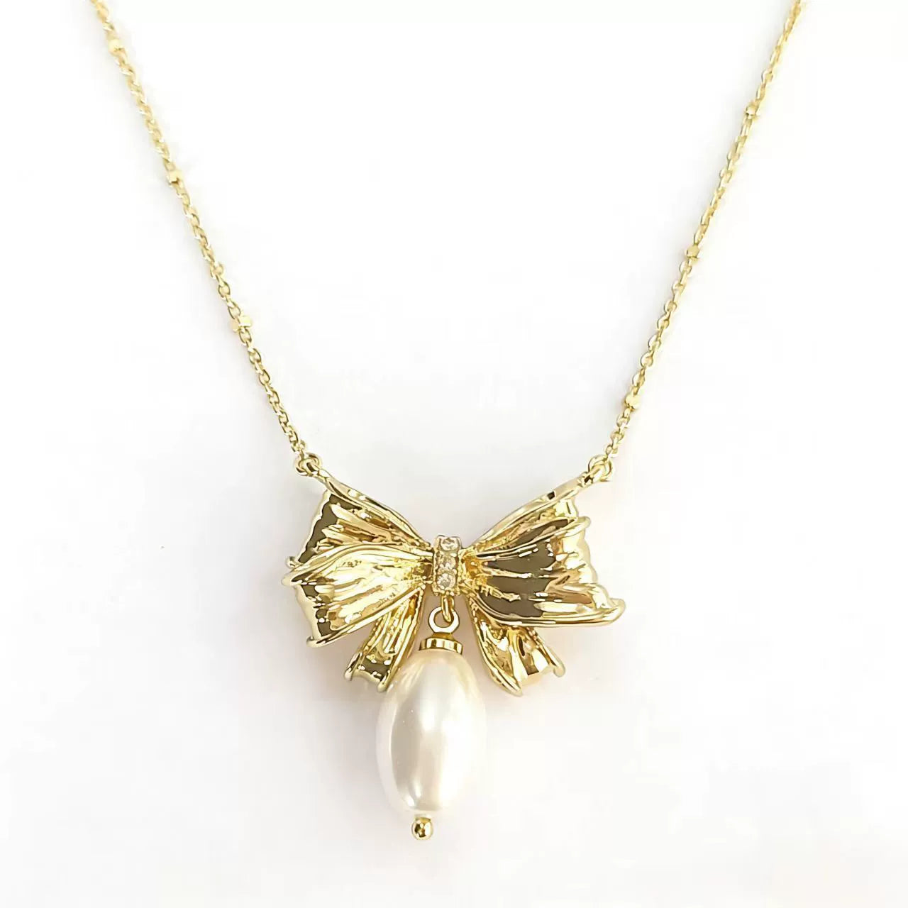 Gold bow pendant necklace with gold-tone ribbon and pearl drop center
