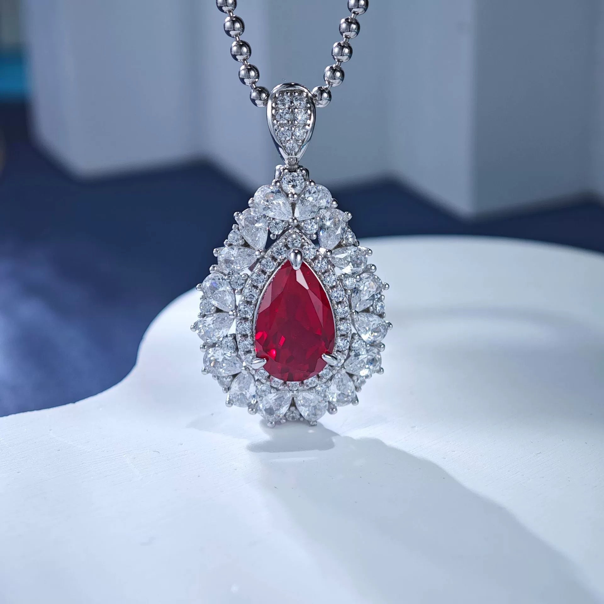 Sterling silver ruby teardrop pendant necklace with diamond halo and beaded chain