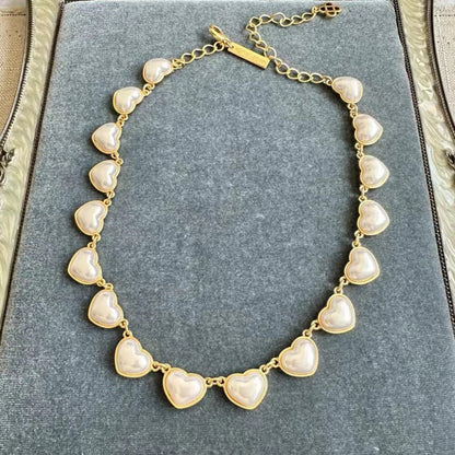 White heart-shaped necklace with gold chain and smooth 3D heart charms