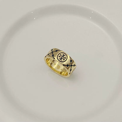 Round logo metal ring with white enamel clover pattern on gold-tone band