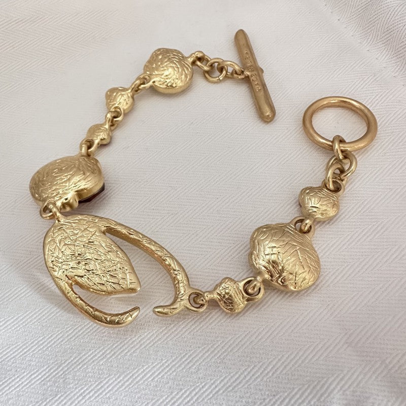 Gold-tone textured charm bracelet with oval links and clasp
