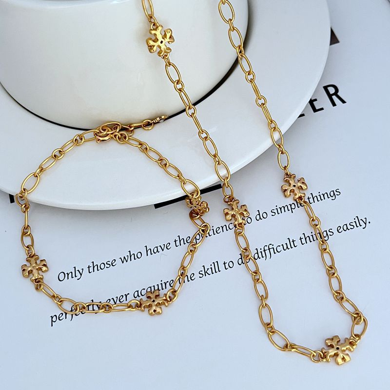 Gold-tone chain bracelet and necklace with clover logo link charms