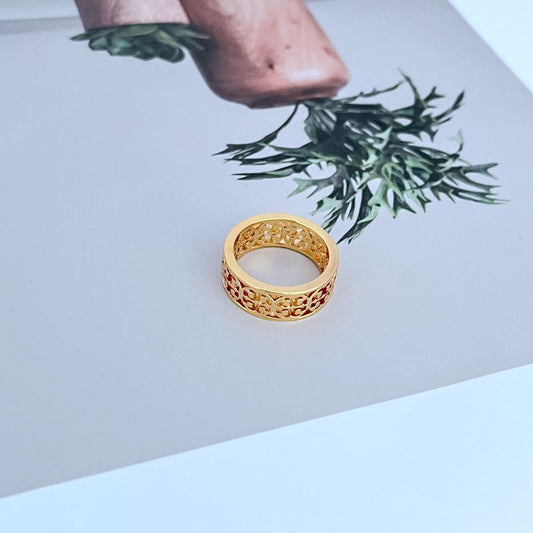 Gold-tone openwork logo band ring on hand view