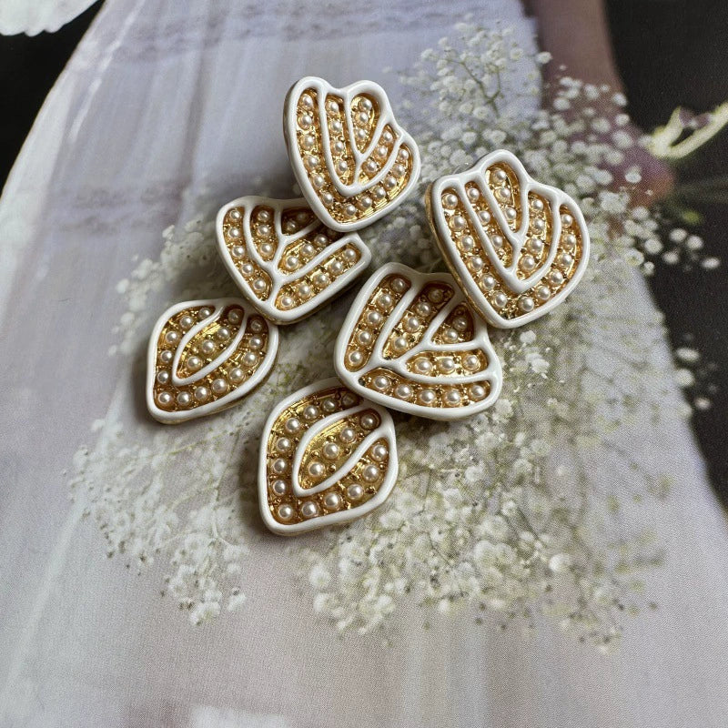 Gold-plated leaf pendant earrings with white enamel hearts and round pearl-like stones