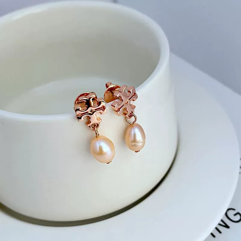 Rose gold-tone stud earrings with dangling cream pearl drops and ornate square settings