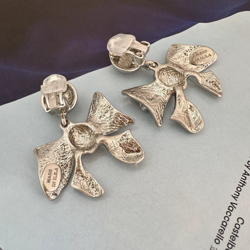 Silver-tone vintage metal bow earrings with clip backs, round ball tops, and stamped metal.