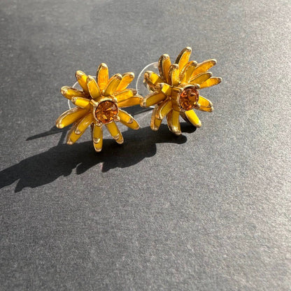 Gold enamel flower stud earrings with yellow petal accents and amber center stones
