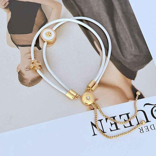 White leather bracelet with gold round logo charm, toggle clasp and chain extender