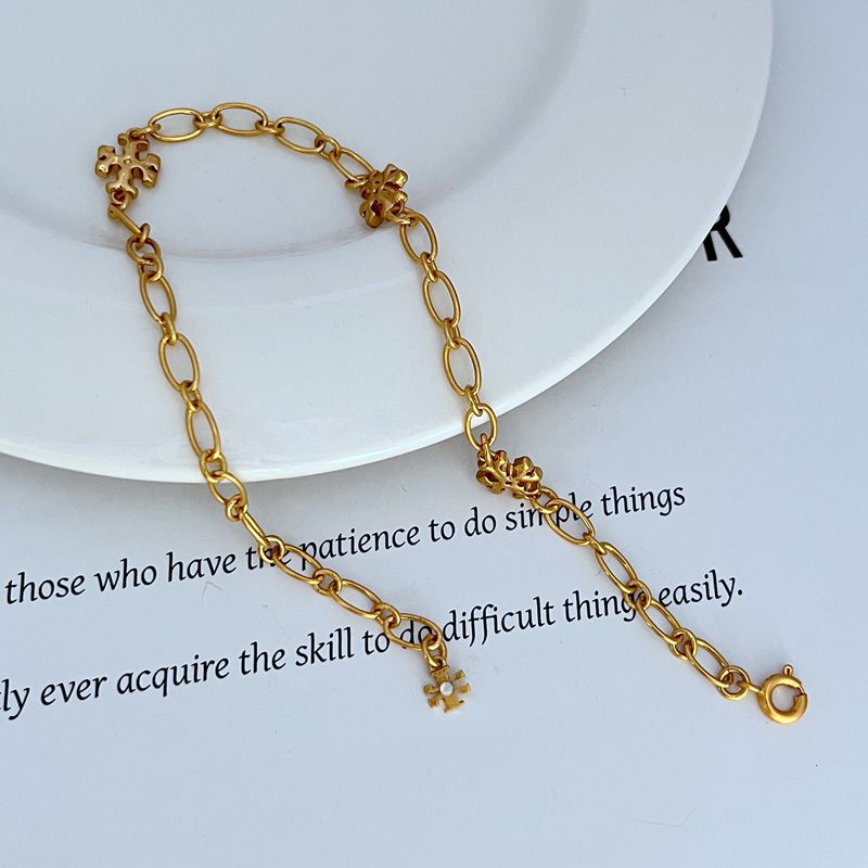 Gold-tone chain bracelet with clover logo links and ring clasp