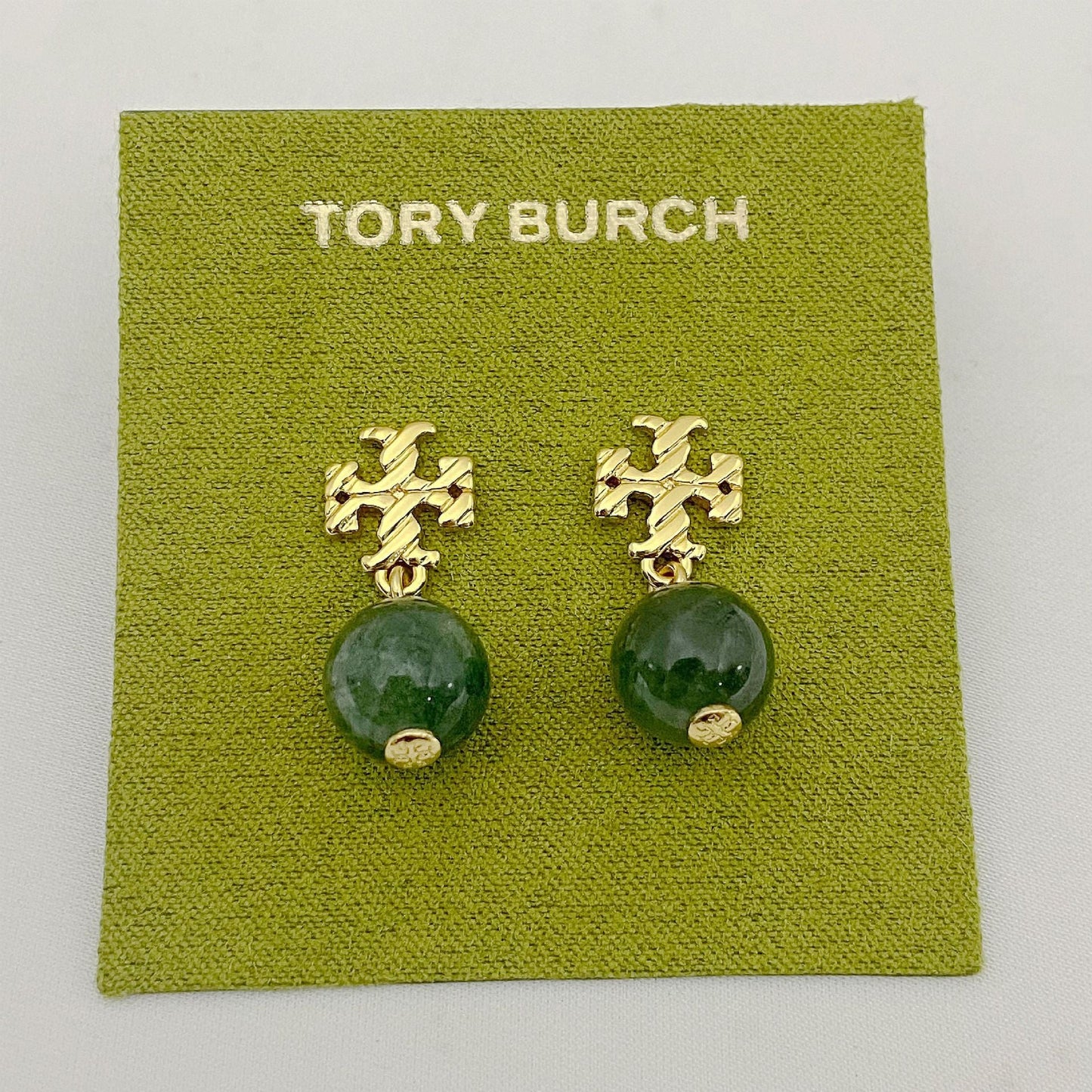 Gold-tone agate pendant earrings with round green stones and leaf-like motif
