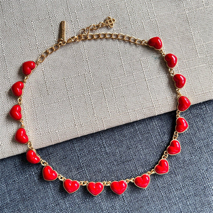 Red heart-shaped necklace with gold chain and glossy 3D heart pendants