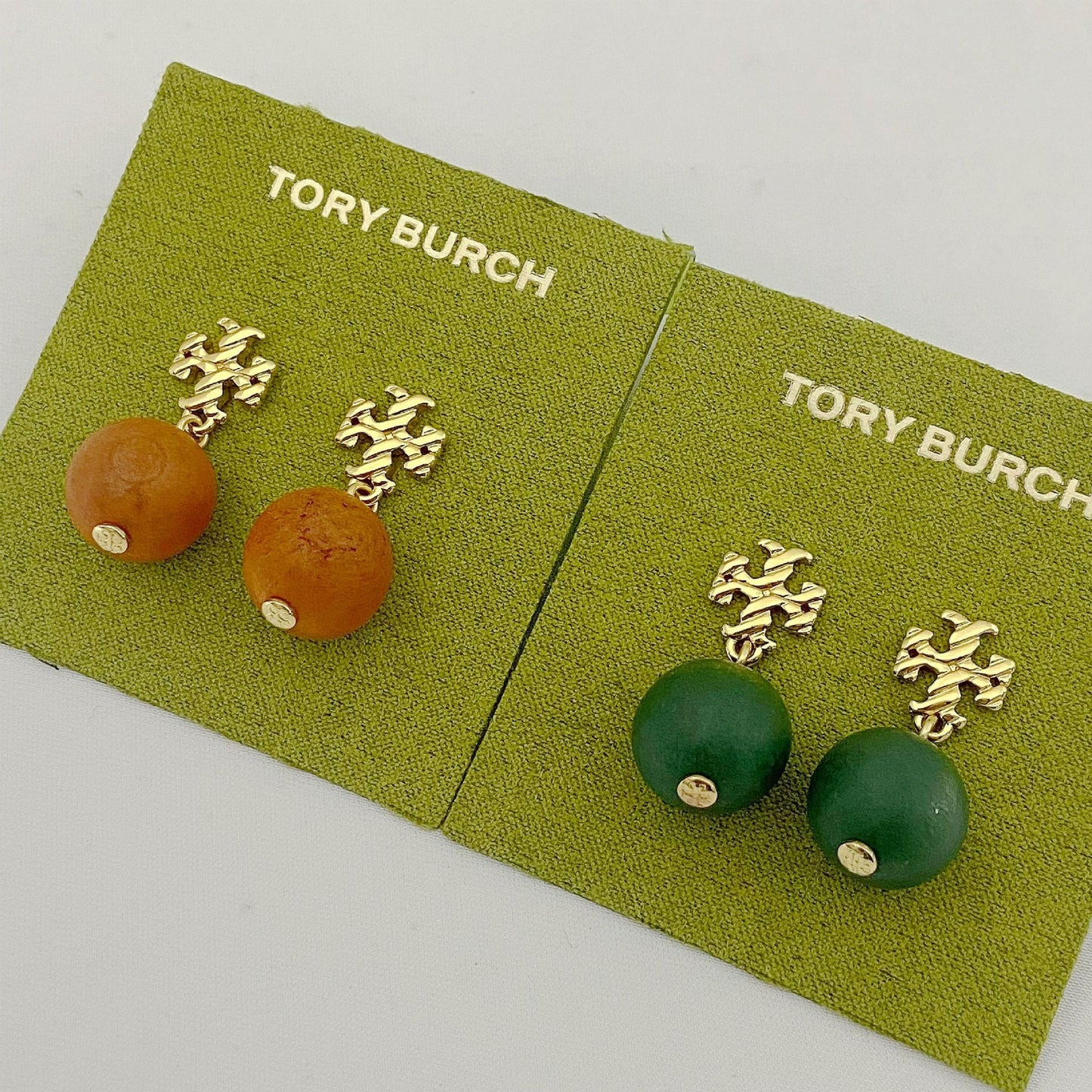 Tory Burch logo beaded pendant earrings, green and amber round beads, gold tone