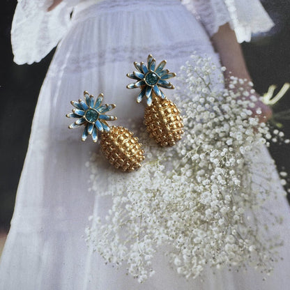 Enamel flower and pineapple diamond earrings with blue flower tops and gold textured drops.