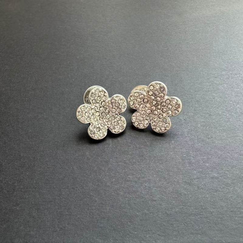 Silver-tone floral stud earrings with clear rhinestones