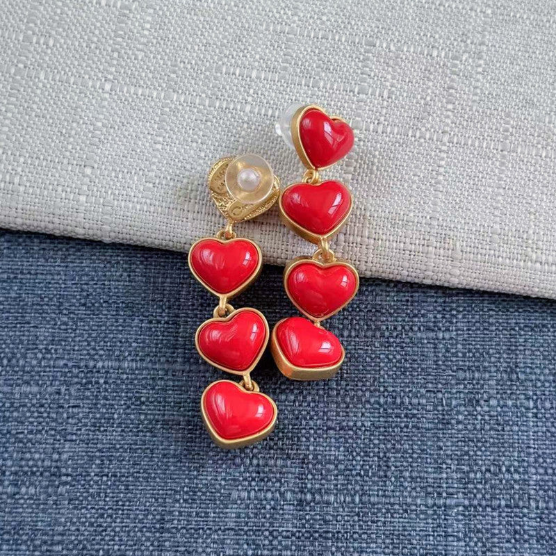 Heart-shaped long drop earrings with red hearts, pearl stud, and gold-tone links