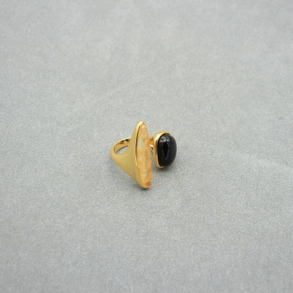 Gold open ring featuring black oval cabochon and arched light marbled setting.