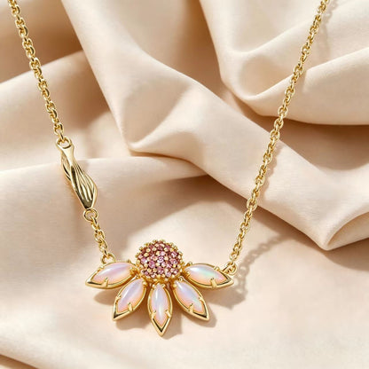 Gold-tone daisy flower pendant necklace with pink rhinestone center and pastel pink petals