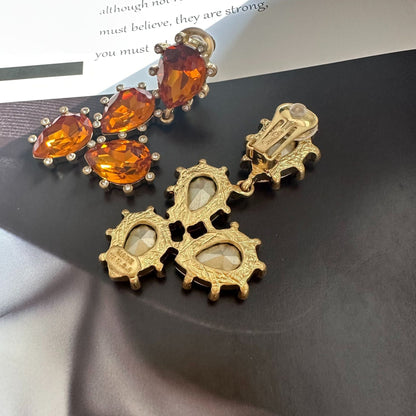Cactus-cut glass ear clips with amber-orange stones, gold-tone clip backs visible