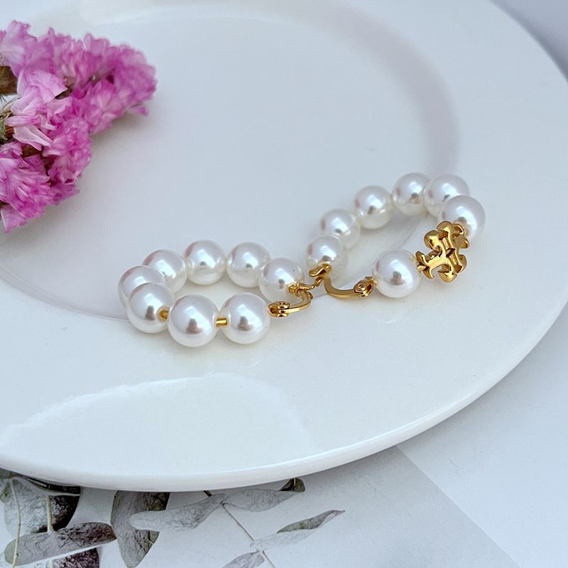 Gold-tone hoop earrings with round white pearl strand and small decorative clasp