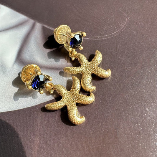 Vintage gold starfish stud earrings with dark blue round accents