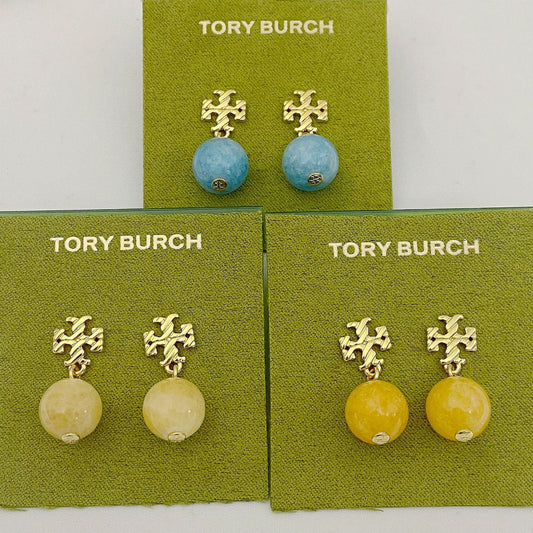 Gold-tone logo charm agate ball earrings on display cards (blue, off-white, yellow)