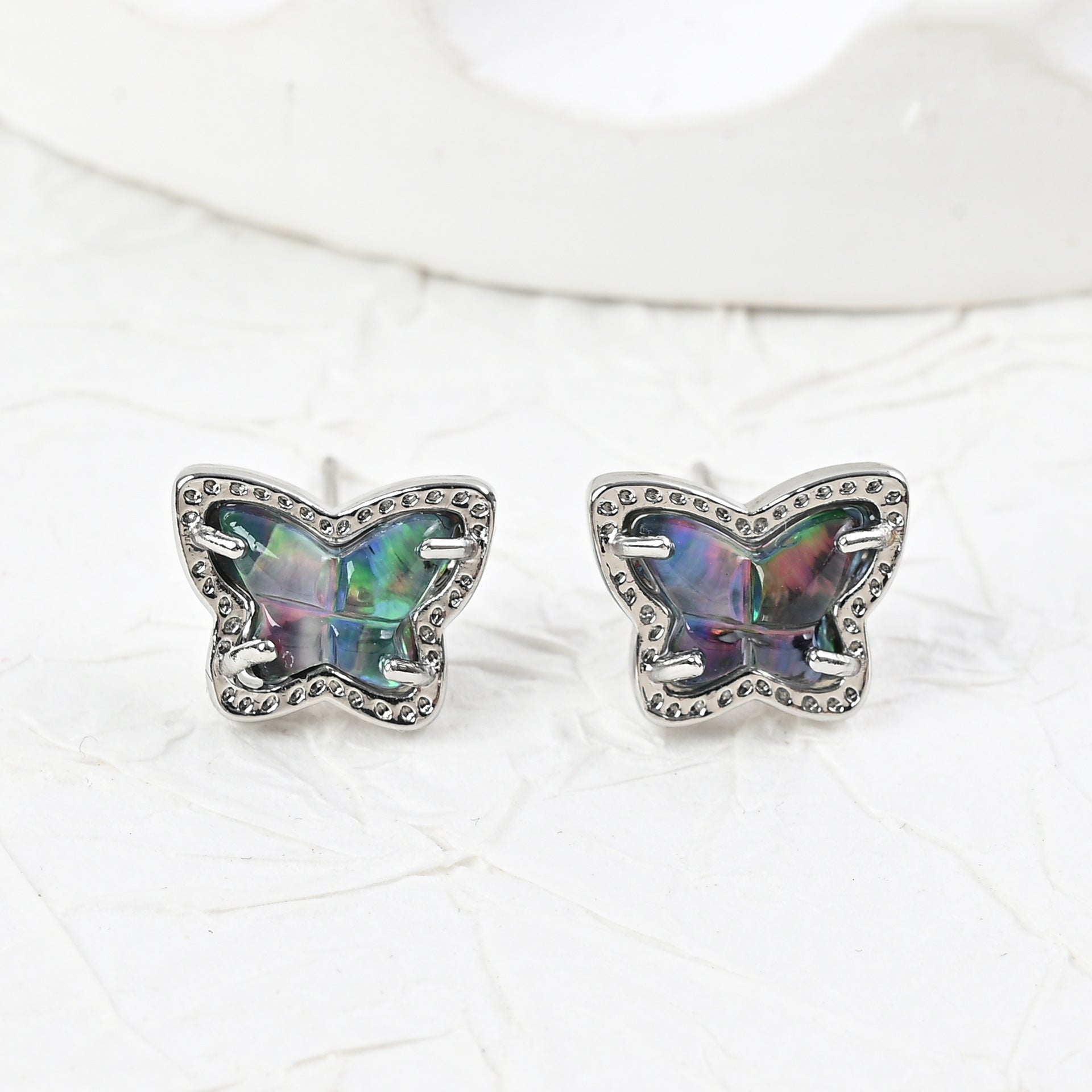 Silver butterfly stud earrings with iridescent multi-color stones