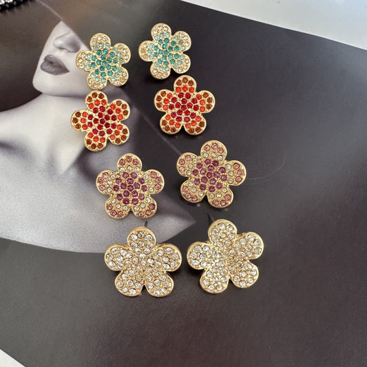 Floral rhinestone stud earrings in teal, red, purple, and clear (set on display)