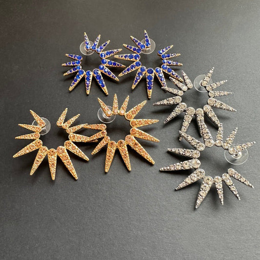 Blue sapphire-style starburst stud earrings with gold-tone prongs and clear accents