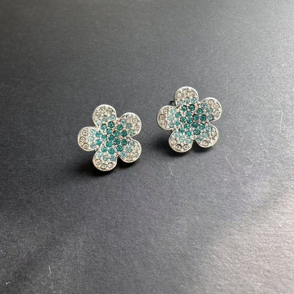 Silver-tone floral stud earrings with teal and clear rhinestones