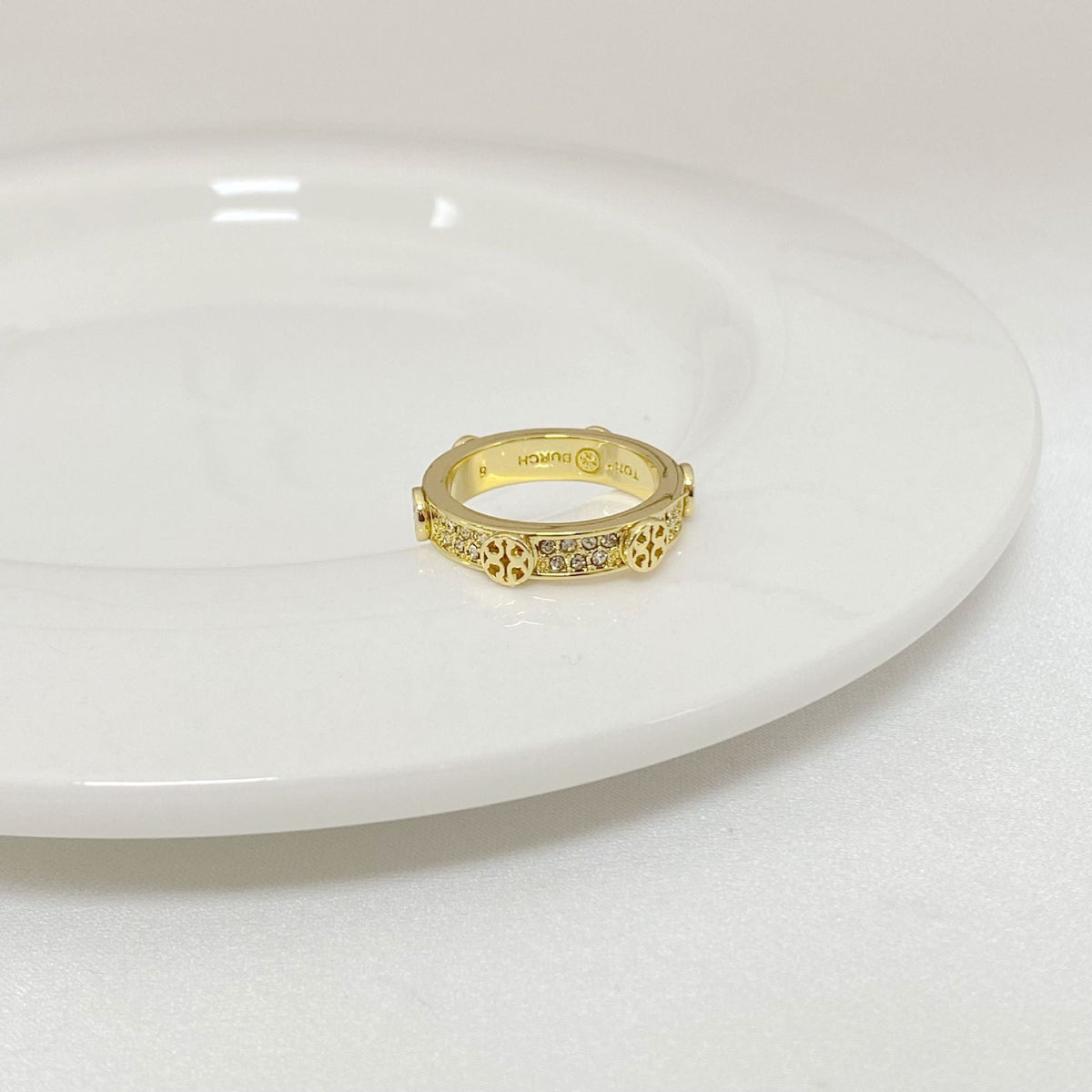 Gold-tone rhinestone ring with round bezel, centered stones on top