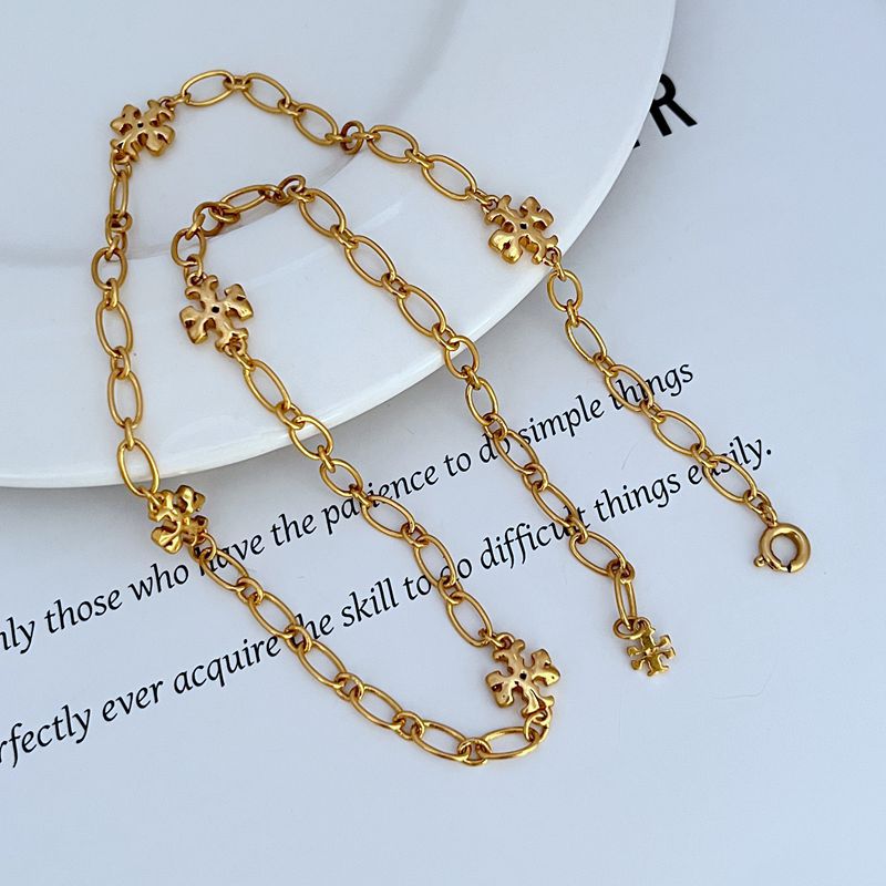 Gold-tone chain bracelet and necklace set with clover logo link charms