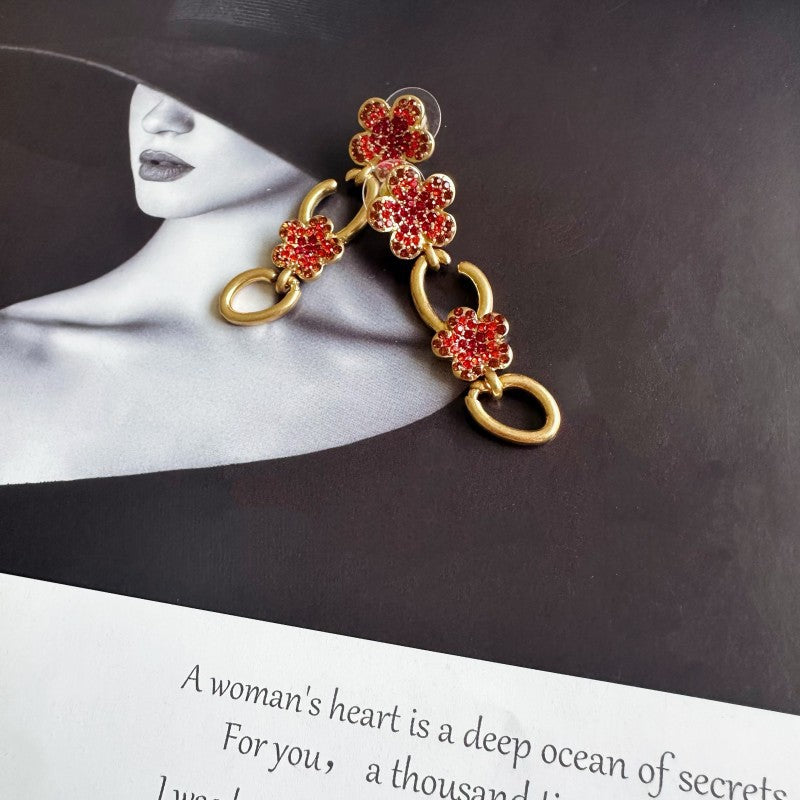Floral dangle hoop earrings in gold tone with red crystal flower clusters and loops