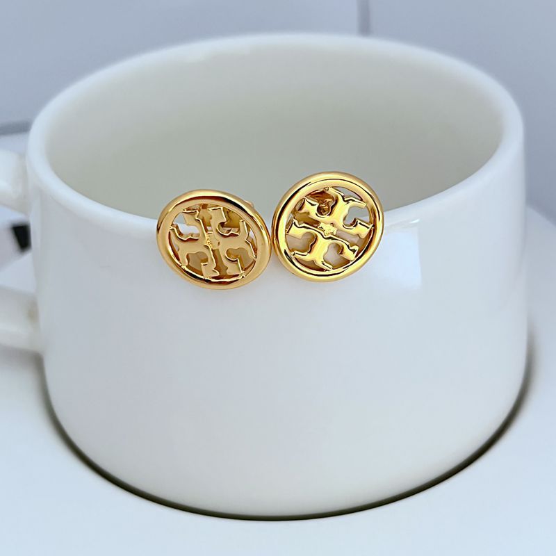 Gold round logo metal stud earrings with openwork pattern, close-up on pair